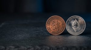 Two physical coins of different colours side-by-side on a neutral dark surface