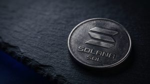 A physical coin engraved with the Solana symbol on a neutral dark surface
