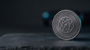 Physical silver coin engraved with Stellar XLM symbol on dark surface