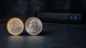Two physical coins of different colors side-by-side on a neutral dark surface representing Kraken and Gemini