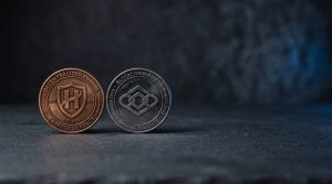 Two physical coins of different colours side-by-side on a neutral dark surface