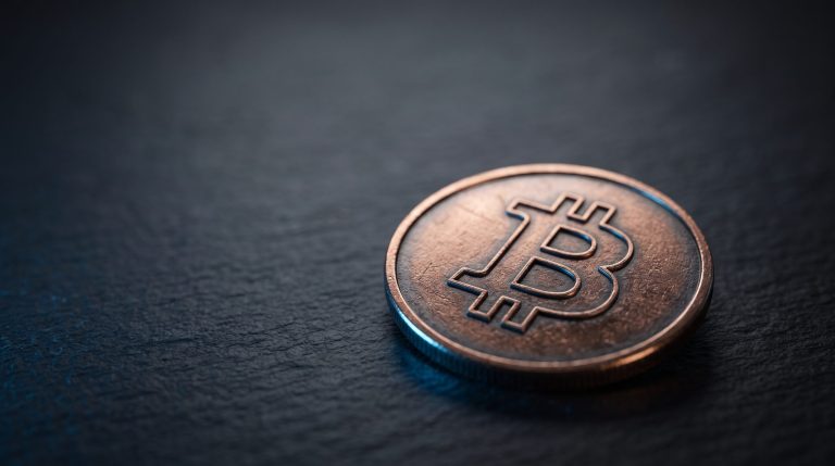 A physical coin engraved with the generic symbol of Fetch.ai (FET)